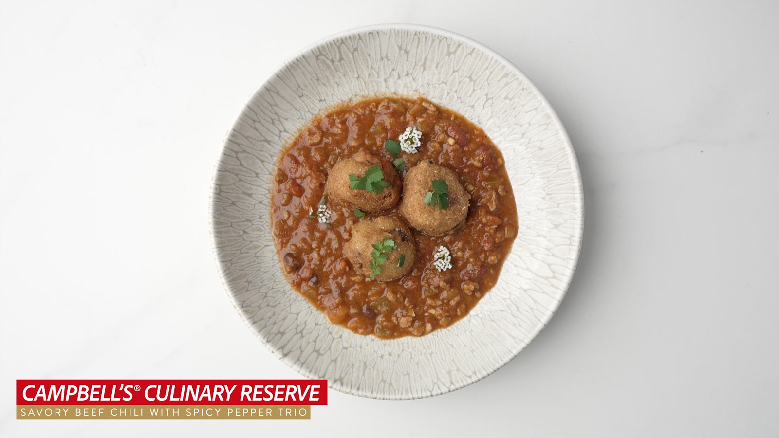 <em>Campbell’s® Culinary Reserve </em> Frozen Ready to Eat Savory Beef Chili with Spicy Pepper Trio with Pork Belly Hushpuppies